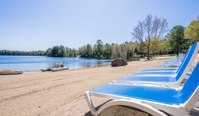 Bonnie Lake Resort | Beautiful freshly combed sandy beach, with lounge chairs overlooking the peaceful lake | Muskoka resort living