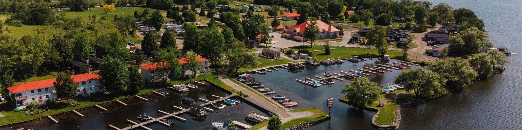 Aerial view of Golden Beach Resort in The Kawarthas from the lake facing the resort showing a marina with boats.