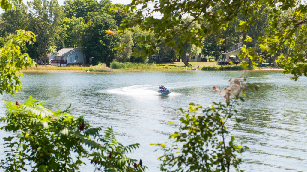 View of two people riding a seadoo on the lake at Cherry Beach Resort. 